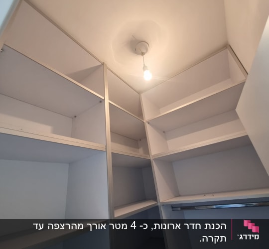מדפים לבנים מותקנים בחדר קטן עם תאורה עליונה
